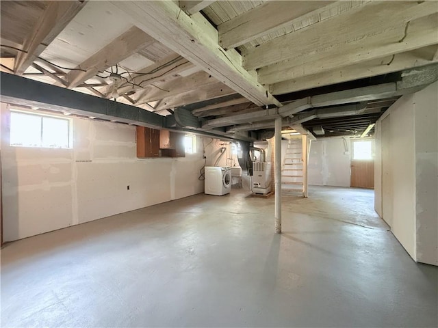 basement with washing machine and clothes dryer, stairs, and heating unit