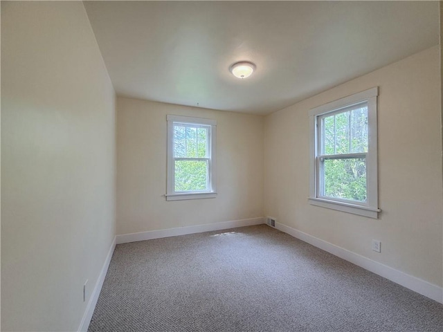 carpeted spare room with baseboards