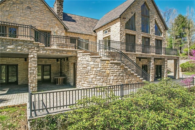 1700 Forker Blvd, Hermitage, PA 16148 - back of property with a balcony, a fenced backyard, stone siding, and a chimney