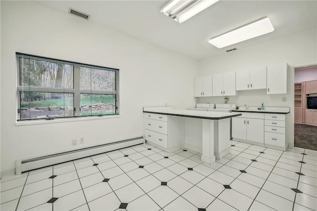1700 Forker Blvd, Hermitage, PA 16148 - kitchen featuring a baseboard heating unit, a peninsula, white cabinets, a sink, and oven