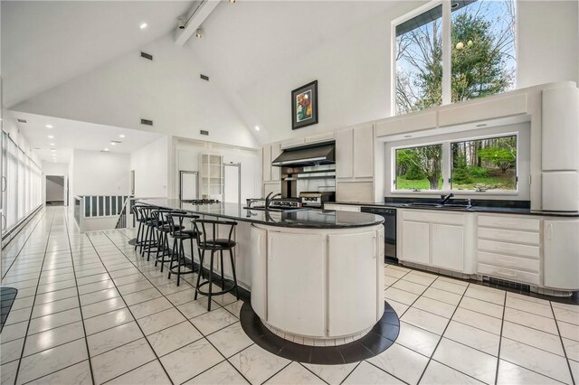 1700 Forker Blvd, Hermitage, PA 16148 - kitchen featuring high vaulted ceiling, dark countertops, black dishwasher, a sink, and a kitchen bar