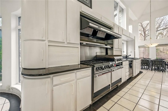 1700 Forker Blvd, Hermitage, PA 16148 - kitchen featuring stainless steel stove, dark countertops, white cabinetry, under cabinet range hood, and a high ceiling