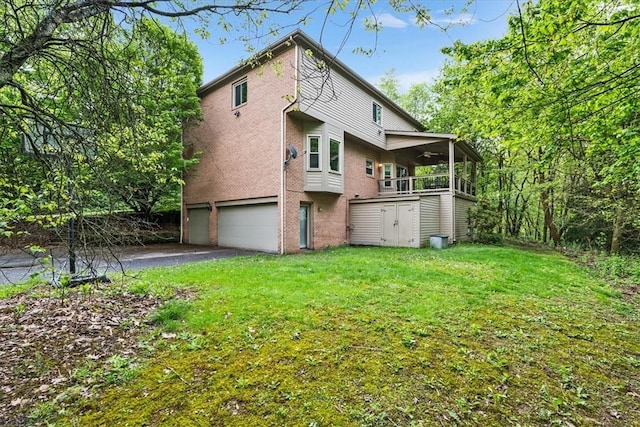 106 Briar Hill Dr, Jackson Twp But, PA 16063 - back of property featuring an attached garage, a yard, a ceiling fan, brick siding, and a storage unit