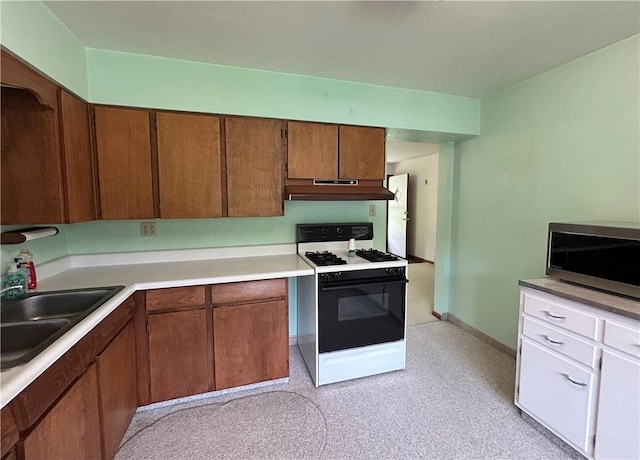 90 Dague Ln, South Franklin, PA 15301 - kitchen with gas range, stainless steel microwave, under cabinet range hood, light countertops, and a sink