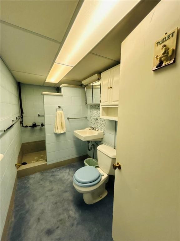 90 Dague Ln, South Franklin, PA 15301 - full bathroom featuring a sink, toilet, a tile shower, concrete block wall, and concrete flooring