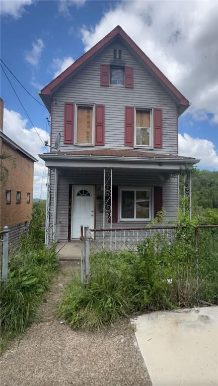 view of front facade with covered porch and fence