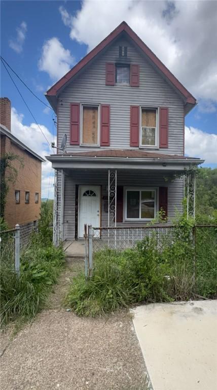 view of front of property featuring a porch and fence