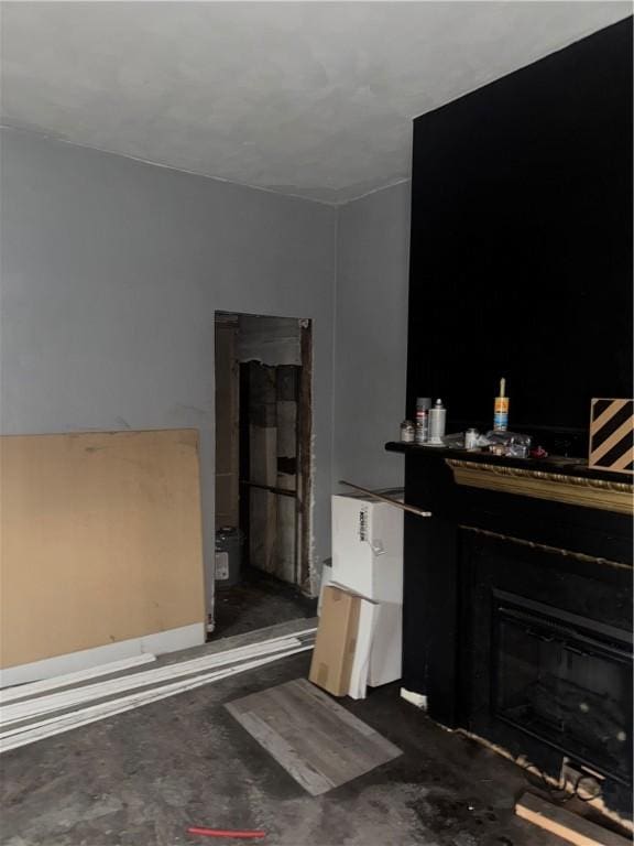 living room featuring unfinished concrete floors and a fireplace