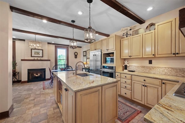 kitchen with stainless steel appliances, a sink, beamed ceiling, light brown cabinetry, and baseboards