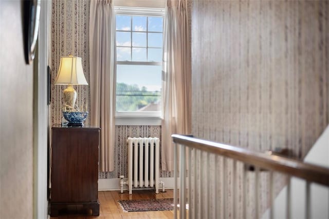 sitting room with radiator heating unit and wood finished floors