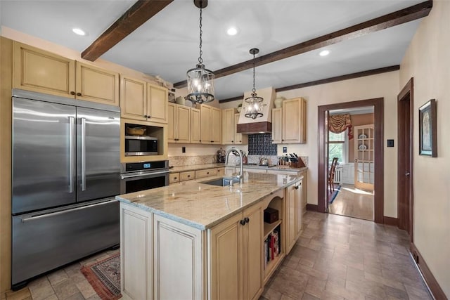 kitchen featuring stainless steel appliances, a sink, baseboards, beamed ceiling, and stone tile flooring