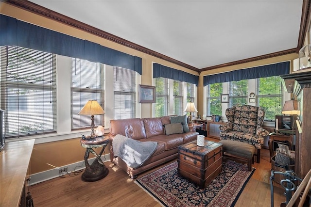 living area with hardwood / wood-style flooring, crown molding, and baseboards