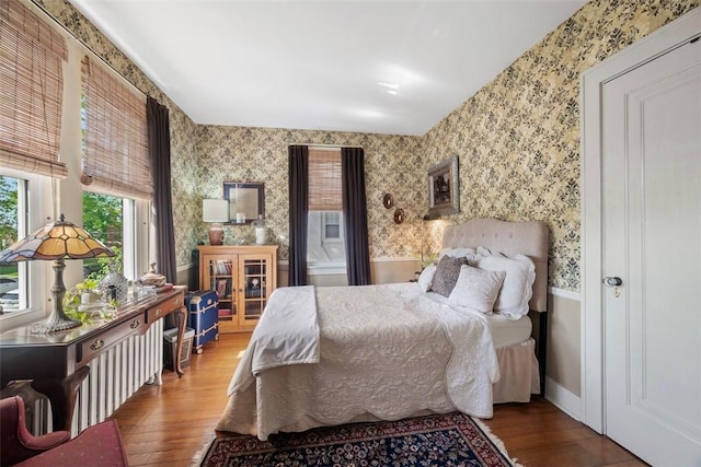 bedroom featuring wood finished floors and wallpapered walls