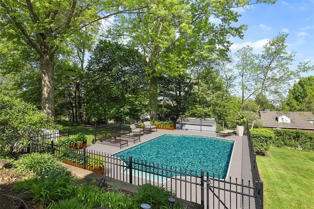 view of pool featuring fence, a patio area, and view of wooded area