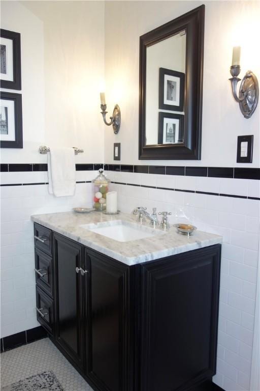bathroom featuring tile walls, vanity, a wainscoted wall, and tile patterned floors