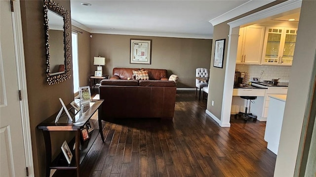 living area with dark wood-style floors, ornamental molding, and baseboards