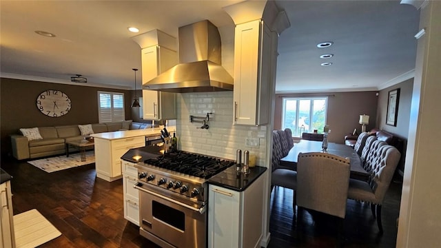 kitchen featuring open floor plan, wall chimney exhaust hood, stainless steel stove, ornamental molding, and plenty of natural light