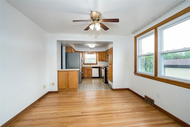 102 Olive Dr, Level Green, PA 15085 - kitchen with stainless steel appliances, brown cabinetry, light countertops, baseboards, and light wood-type flooring