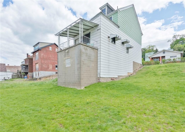 rear view of property with a balcony and a lawn