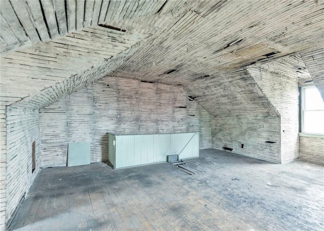 bonus room with wood-type flooring and vaulted ceiling