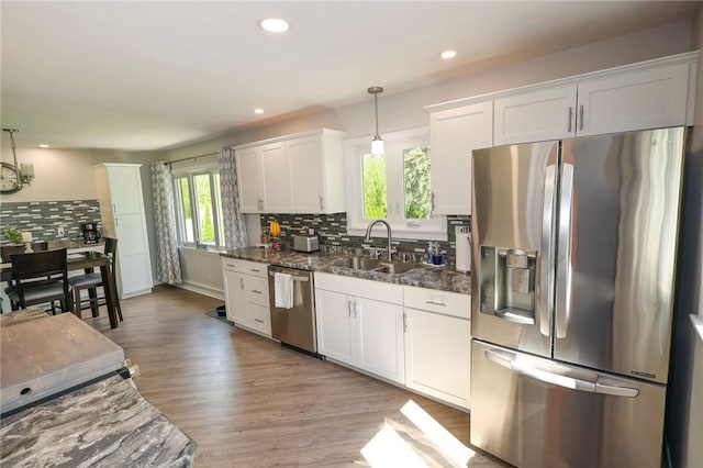 kitchen with appliances with stainless steel finishes, decorative backsplash, a sink, white cabinetry, and recessed lighting