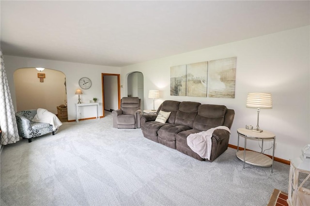 living area with arched walkways, carpet floors, and baseboards