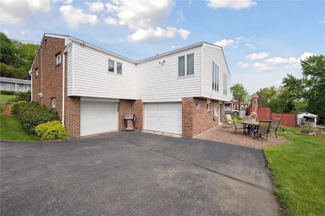 view of home's exterior featuring brick siding, an attached garage, and asphalt driveway