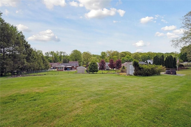 view of yard with a storage unit, an outdoor structure, and view of wooded area