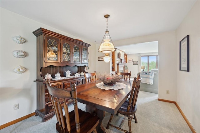 dining area featuring light colored carpet and baseboards