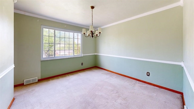 empty room featuring a chandelier, carpet floors, ornamental molding, and baseboards