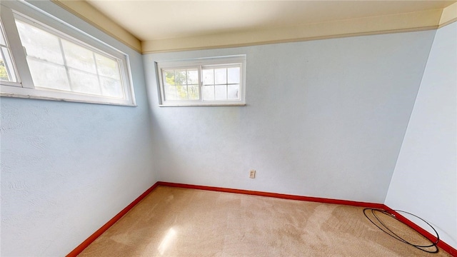 carpeted spare room featuring baseboards