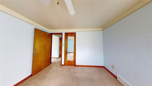 unfurnished room featuring light colored carpet and baseboards