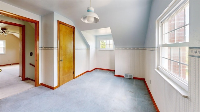 additional living space with carpet, baseboards, lofted ceiling, and a ceiling fan