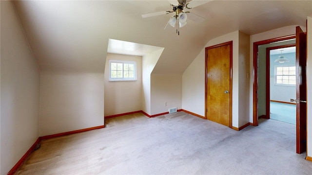 additional living space featuring lofted ceiling, carpet floors, baseboards, and ceiling fan