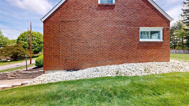 view of property exterior with a lawn and brick siding