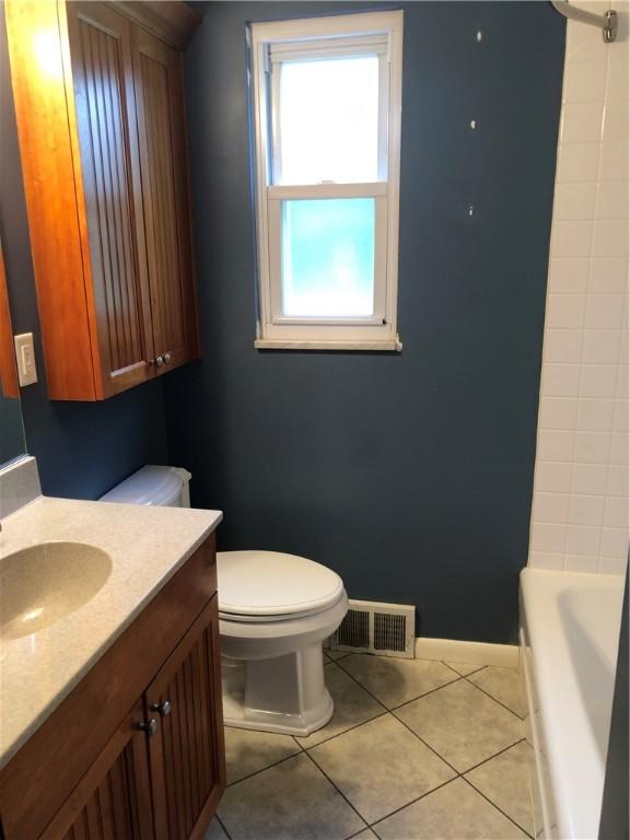bathroom featuring toilet, tile patterned floors, vanity, and baseboards