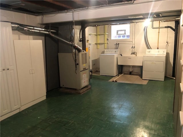 basement with independent washer and dryer, heating unit, tile patterned floors, and a sink