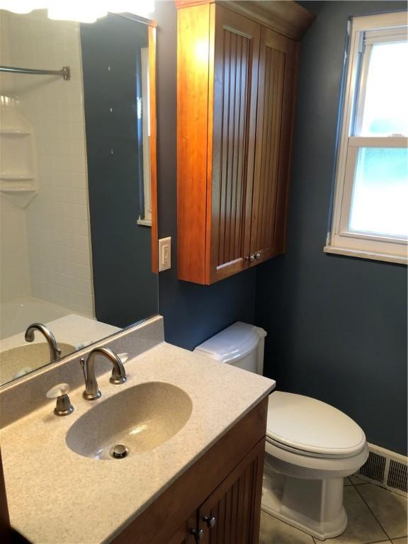 full bathroom featuring tile patterned flooring, toilet, a shower, and vanity