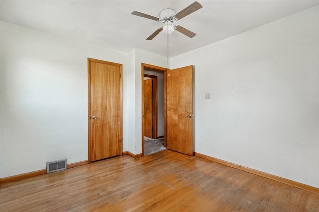 spare room featuring ceiling fan, wood finished floors, and baseboards