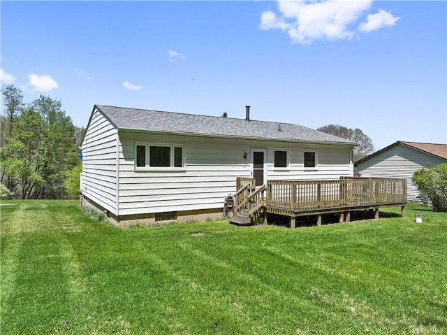 back of house featuring a deck, a yard, and roof with shingles