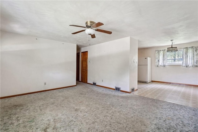 carpeted empty room featuring ceiling fan and baseboards