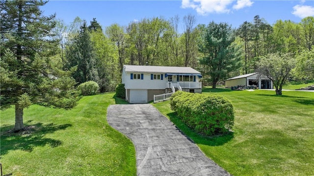 split foyer home with stairway, asphalt driveway, an attached garage, and a front lawn
