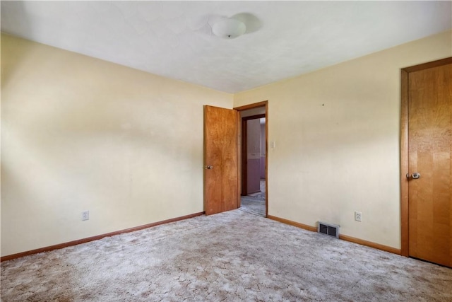 unfurnished room with carpet and baseboards