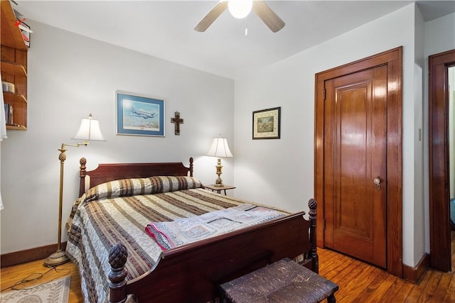bedroom featuring wood finished floors, baseboards, and ceiling fan