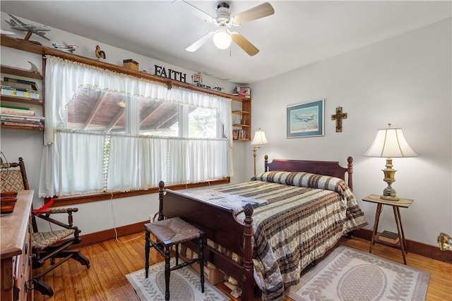 bedroom with wood finished floors, baseboards, and a ceiling fan