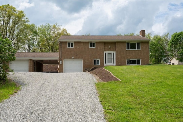 bi-level home with gravel driveway, a chimney, a front yard, and brick siding