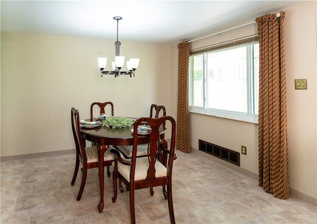 dining space featuring a chandelier and baseboards