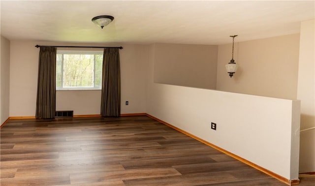 unfurnished room featuring wood finished floors and baseboards