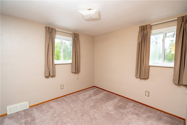 spare room featuring baseboards and carpet floors
