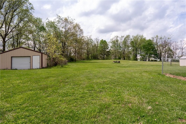 view of yard featuring a garage and an outbuilding